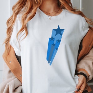May include: White t-shirt with a blue and gray starburst design.