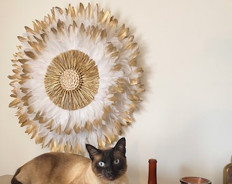 JUJUHAT “PRECIOUS GOLD” with its white and gold feathers and its heart in gold raffia and cowrie shells