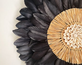 JUJUHAT "NEW BLACK" in black feathers with a heart made of raffia and cowrie shells