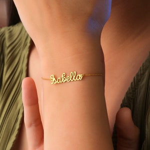 Könnte beinhalten: Goldarmband mit dem Namen "Isabella" in Kursivschrift.