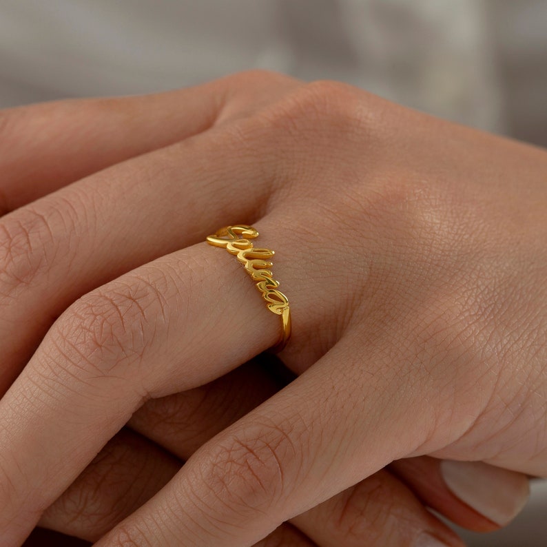 May include: Gold ring with the name "Luna" spelled out in cursive.