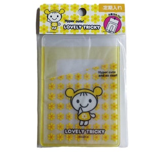 May include: Yellow plastic card holder with a cartoon girl design. The holder has a clear plastic window for displaying a card. The text "Hyper cute! LOVELY TRICKY" is printed on the top of the holder. The text "Hyper cute and so cool! LOVELY TRICKY @san-x" is printed on the bottom of the holder.