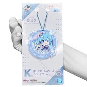 May include: A blue and white rubber charm featuring a cartoon character with blue hair and a white rabbit. The charm is attached to a silver chain and has the text "SNOW MIKU 2017" on it. The charm is packaged on a white card with the text "Snow Miku All Stars Rubber Charm" in Japanese.