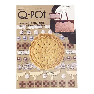 May include: A magazine cover showcasing a seasonal look book and archive collection for the Q-Pot. jewellery brand. The cover features a large biscuit with the Q-Pot. logo and a pink tote bag with the Q-Pot. logo.