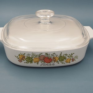 Peut inclure: Plat à gratin blanc avec un couvercle en verre et un motif floral représentant des légumes et le texte "L'Echalote".