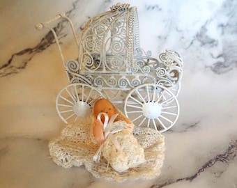 Vintage miniatuur metalen kinderwagen met pop, fles en deken