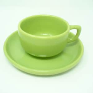 Peut inclure: Une tasse à thé et une soucoupe en céramique verte. La tasse a une forme arrondie et une poignée. La soucoupe est de forme ronde simple.