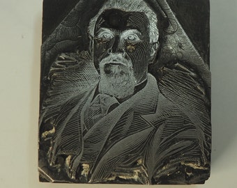 May include: A black and white engraved printing block featuring a portrait of a man with a beard and mustache. The man is wearing a suit and tie.