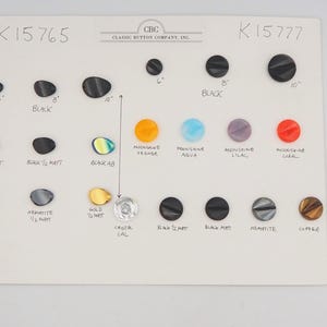 May include: A display of various buttons in different colors and finishes, including black, copper, gold, and iridescent. Sizes are indicated in inches, ranging from 6" to 10". The card also features text such as "Black Matt" and "Crystal Cal".