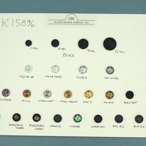 May include: A display of various buttons in different colors, sizes, and finishes. The buttons range from 11 mm to 22 mm in diameter and include black, crystal, and iridescent options. The text "Classic Button Company, Inc." is visible.