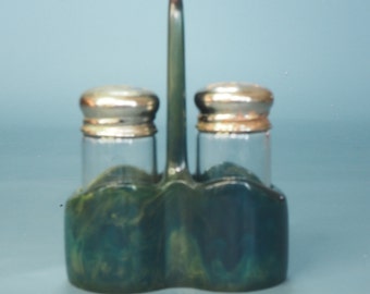 Peut inclure: Un ensemble de salière et poivrière vert et or avec un support assorti. Les shakers ont des dessus argentés.