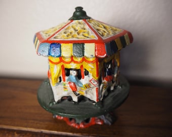 Vintage gietijzeren draaiende carrousel muntenbank: speelgoeddraaimolen