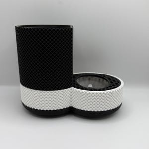 May include: A black and white pet feeder with a textured design. The feeder has a tall, rectangular section and a round, connected section. The round section has a clear, circular opening. The design is a repeating pattern of small squares.
