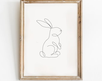 May include: A framed line drawing of a rabbit in a simple, minimalist style. The rabbit is depicted in a standing position with its ears perked up.