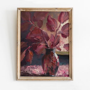 Peut inclure: Une peinture encadrée d'une nature morte représentant un vase rempli de feuilles de couleur bordeaux. Le vase est de couleur brun foncé et a une surface texturée. L'arrière-plan est de couleur brun clair.