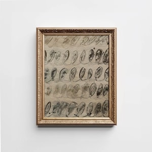 May include: Abstract artwork in a gold ornate frame. The art piece features rows of black and gray oval shapes with looping lines on a beige background. The frame has a detailed, textured design.