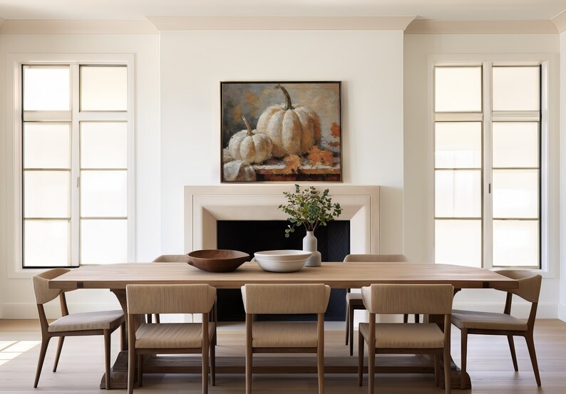 Pode incluir: Uma mesa de jantar de madeira com seis cadeiras, uma tigela de madeira, uma tigela branca e uma pintura de ab&oacute;boras brancas na parede acima de uma lareira.