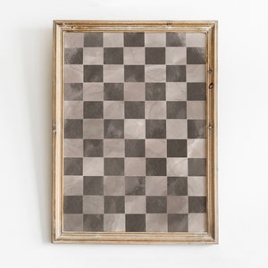 May include: A framed print of a checkered pattern in shades of brown and beige. The frame is a light wood color.