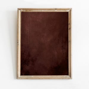 May include: A rectangular framed artwork featuring a deep burgundy abstract design. The artwork is encased in a light-colored, rustic wooden frame. The background is a plain white wall.