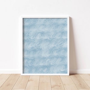 May include: A white framed print with a blue abstract design. The design features a repeating pattern of light blue brushstrokes.