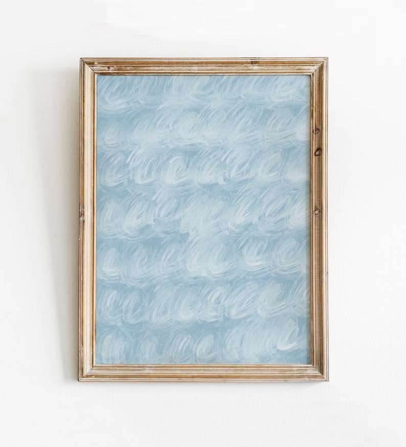 May include: A framed artwork with a light blue background and a white abstract pattern. The frame is made of wood and has a light brown finish.