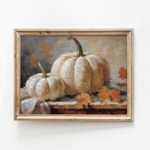 Pode incluir: Uma pintura de duas ab&oacute;boras brancas com caules marrons, sentadas em uma mesa com folhas marrons e laranja. O fundo &eacute; azul claro e cinza.