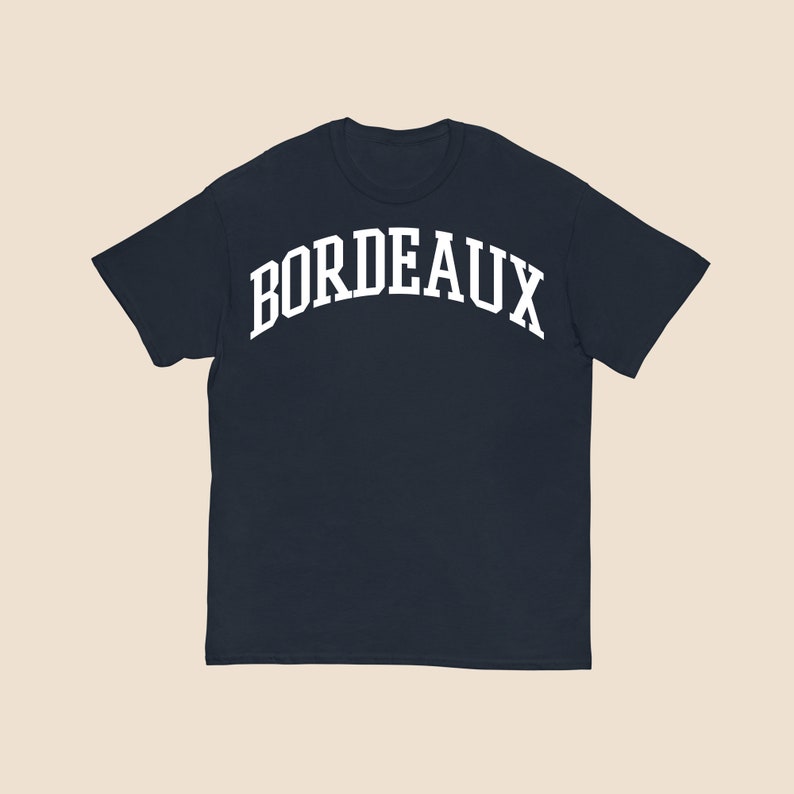 May include: A navy blue t-shirt with a white arch design that says "BORDEAUX".