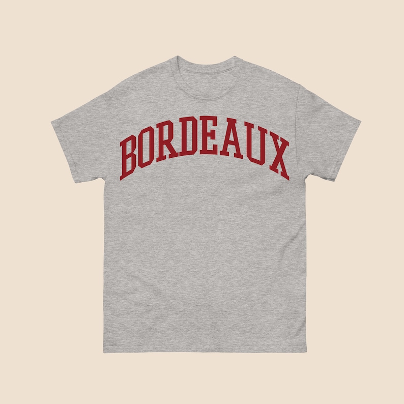 May include: A gray t-shirt with a red arched word "BORDEAUX" printed on the front.