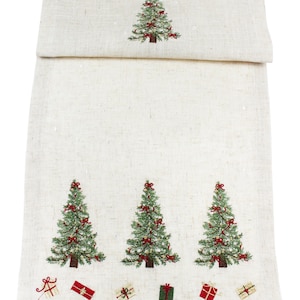 Puede incluir: Camino de mesa navideño color crema con árboles de Navidad verdes bordados, adornados con lazos rojos y pequeños motivos de cajas de regalo. El tejido es texturizado, ideal para la decoración navideña.