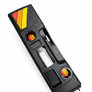 May include: Black automotive console with integrated cup holders and a rectangular storage compartment. The console features a colorful orange, yellow, and red design. The console is designed to fit in a vehicle.