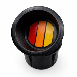 Pu&ograve; includere: Portabicchieri nero con un design a strisce colorate in rosso, arancione e giallo. Il portabicchieri &egrave; realizzato in un materiale resistente e presenta un bordo strutturato. Il design &egrave; in stile retr&ograve;.