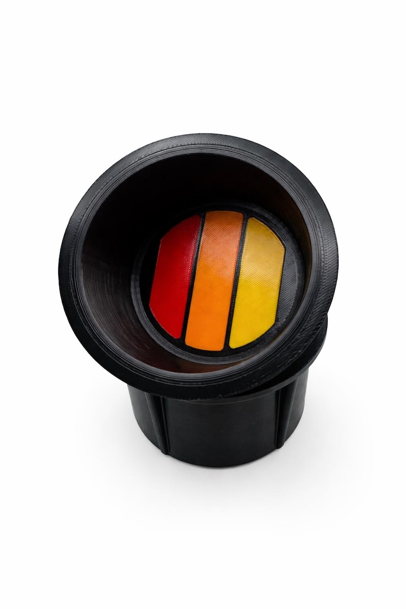 Pu&ograve; includere: Portabicchieri nero con un design a strisce colorate in rosso, arancione e giallo. Il portabicchieri &egrave; realizzato in un materiale resistente e presenta un bordo strutturato. Il design &egrave; in stile retr&ograve;.