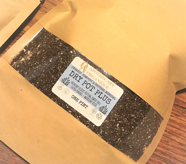 May include: A brown paper bag containing potting soil. A label reads "DRY POT PLUS" and "ONE PINT". The label also includes the words "Organic Compost & Natural Mineral" and "Premium Desert Potting, Super Soil, Extra Porous, Nutrient Rich".