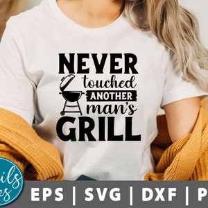 May include: White t-shirt with black text that reads "Never touched another man's grill". A black and white illustration of a grill is above the text.