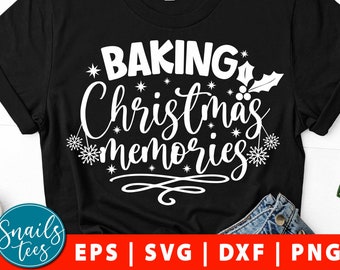 May include: Black t-shirt with white text that reads "Baking Christmas Memories". The text is surrounded by small stars and snowflakes. There is a small holly sprig in the upper right corner of the text.