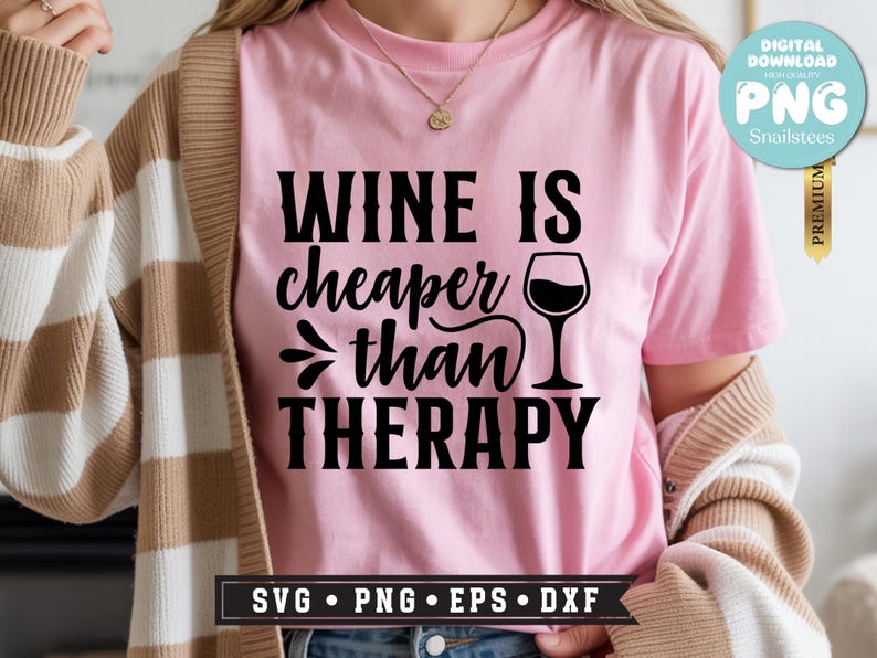 May include: Pink t-shirt with the phrase "WINE IS cheaper than THERAPY" in black lettering. A wine glass graphic is next to the text. The shirt also has SVG, PNG, EPS, and DXF file format options.