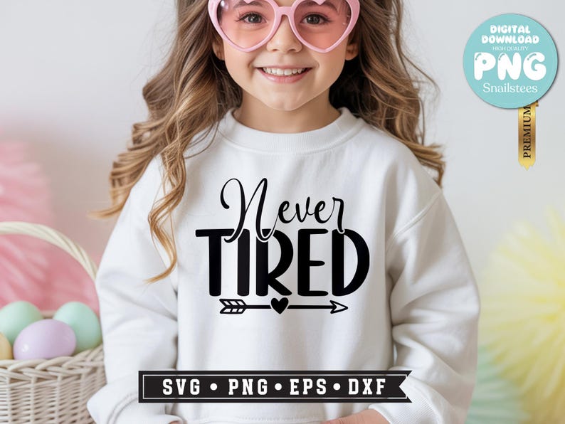 May include: A white sweatshirt with the words "Never Tired" in black script and block letters. Below the text is an arrow with a heart in the middle. The image also includes a digital download graphic.