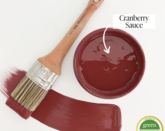May include: A small container of Cranberry Sauce paint with a paintbrush and a swipe of paint. The paint is a deep red color. The container has the text "COUNTRY CHIC" on the side. The paint is certified Green Wise Gold.