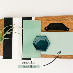 May include: A wooden cutting board with a black handle, a green and black striped fabric, and a green paint swatch labeled "Happy Hour".