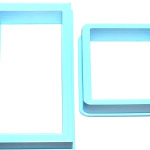 May include: Two light blue plastic picture frames. The larger frame is rectangular and the smaller frame is square.
