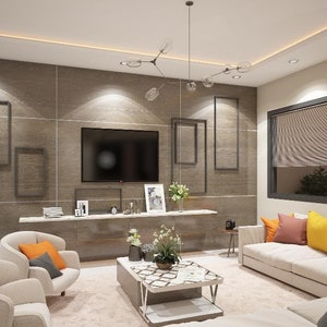May include: A living room with a white couch and two armchairs. The couch has several throw pillows in shades of orange, yellow, and pink. There is a coffee table in the center of the room with a patterned top. The wall behind the couch is a light brown with a flat screen TV and several framed pictures.