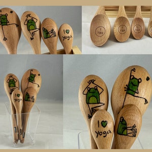 Può includere: Cucchiai dosatori in legno con un design a forma di rana. Le rane sono dipinte di verde e nero, in varie pose yoga. Un cucchiaio dice "I love Yoga". Il set include misure da 1 cucchiaio, 1 cucchiaino, 1/2 cucchiaino e 1/4 cucchiaino.