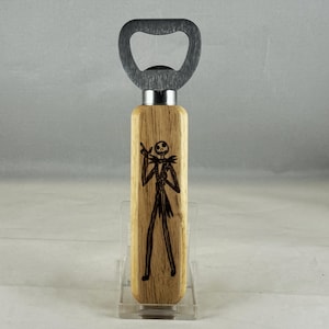 May include: A wooden bottle opener with a metal cap opener and a wood-burned image of Jack Skellington from The Nightmare Before Christmas.