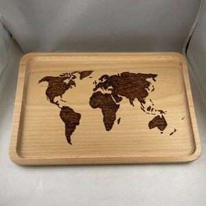 May include: A wooden serving tray with a world map design burned into the surface. The tray is light brown and has a raised edge.