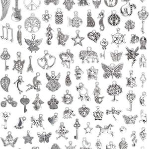 May include: A large collection of assorted silver-toned metal charms featuring various shapes including animals, keys, hearts, stars, butterflies, musical notes, trees, and mythical figures. Each charm includes a small loop for attachment.