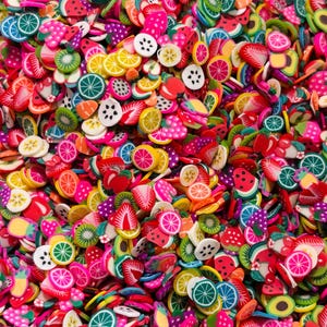 May include: A vibrant assortment of colorful fruit-shaped polymer clay slices. The mix includes watermelon, strawberries, kiwi, lemons, oranges, and other fruits. The slices are in various shades of red, pink, green, yellow, and purple.