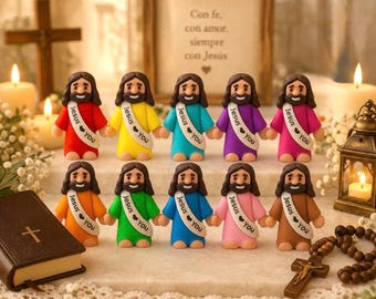 May include: Ten small figurines of Jesus, each wearing a robe in a different solid color, including red, yellow, teal, purple, pink, orange, green, blue, light pink, and brown. Each figurine features a white sash with the text Jesus ❤️ You.
