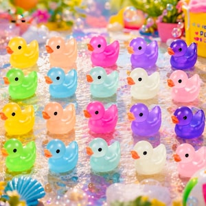 May include: A collection of twenty small rubber ducks arranged in a grid, featuring a variety of vibrant colors including yellow, orange, pink, purple, blue, green, and white, each with a distinct orange beak and black eyes, set against a bubbly surface.