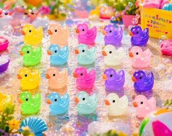 May include: A collection of twenty small rubber ducks arranged in a four-by-five grid. The ducks are translucent and come in various colors including yellow, orange, pink, purple, blue, green, and white, each featuring a distinct orange beak.