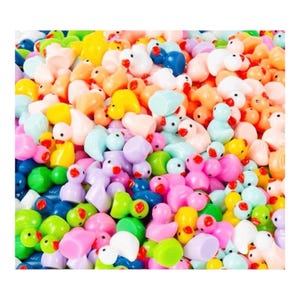 Puede incluir: Un vibrante surtido de pequeñas figuras de patos de colores. Los patos son de varios tonos de rosa, amarillo, azul, verde y naranja, con picos rojos. La imagen es un primer plano, que muestra los patos densamente empaquetados.